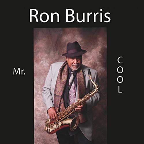 A man in a hat and tie holding a saxophone.